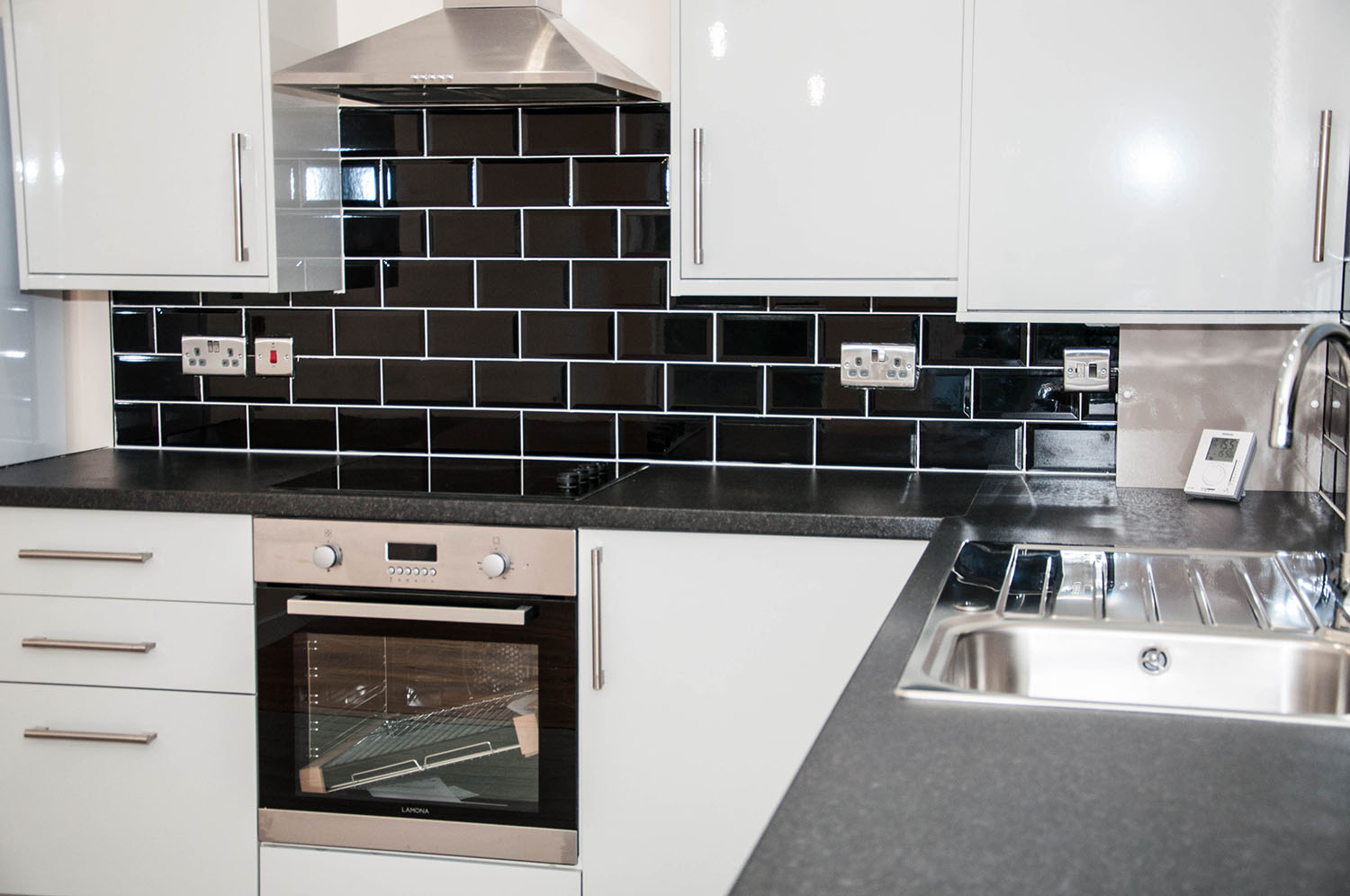 White kitchen with black wall tiles