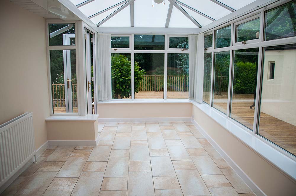 Conservatory with tiled floors and door to back garden