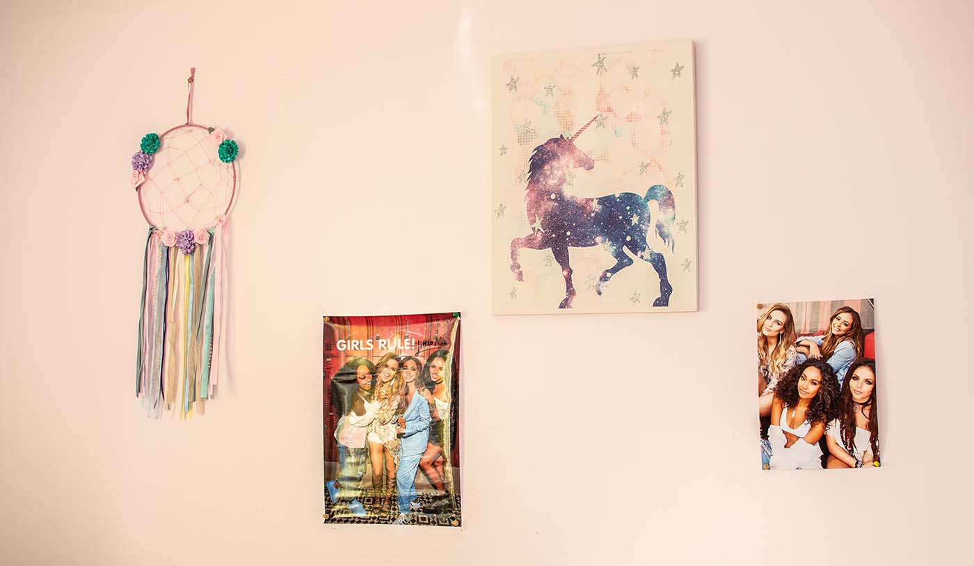 3 posters and a dreamcatcher attached to a wall