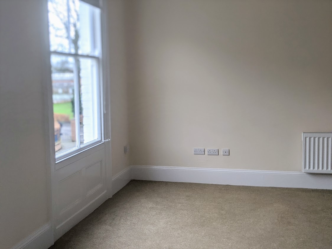 empty living room with carpet and one window