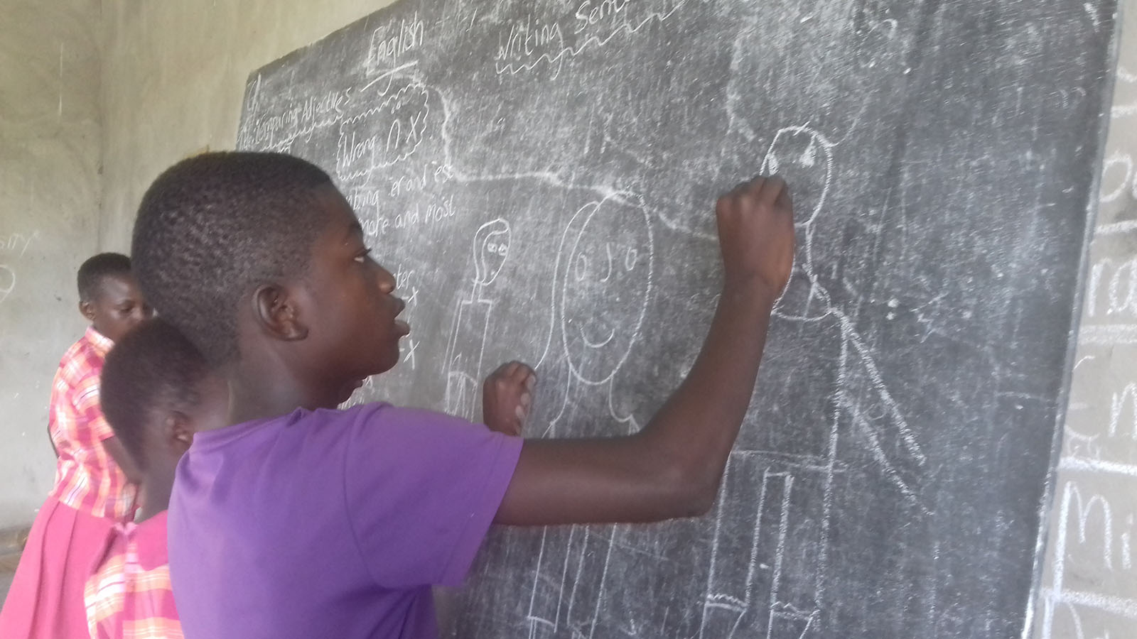 A child drawing with chalk on a blackboard