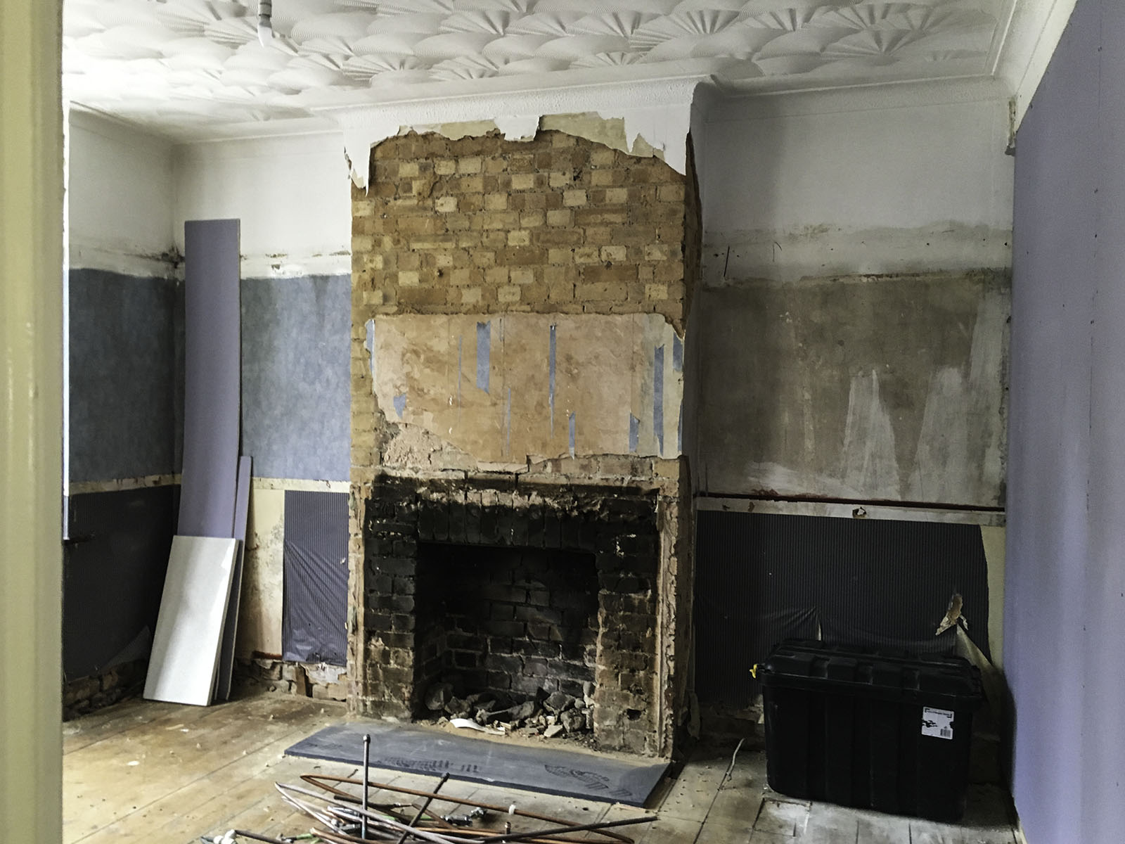 A living room with a large fireplace under construction